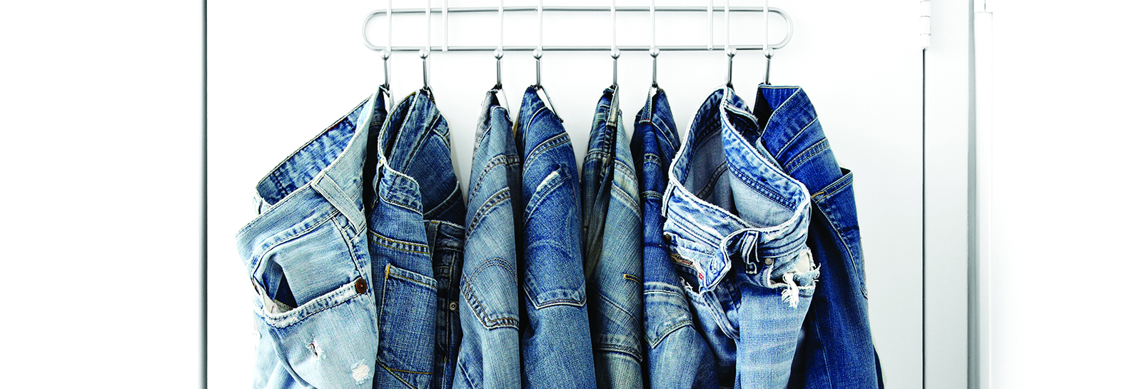 multiple jeans hung up on a hanger