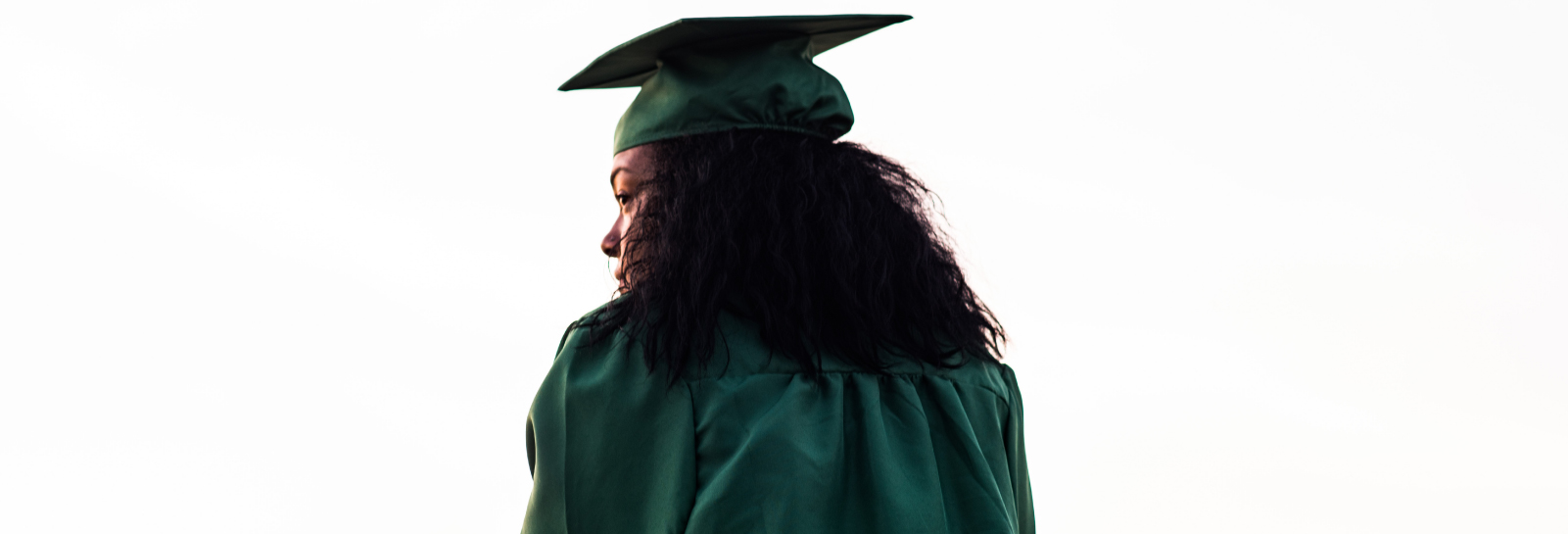 a behind shot of a woman in a graduation cap and gown