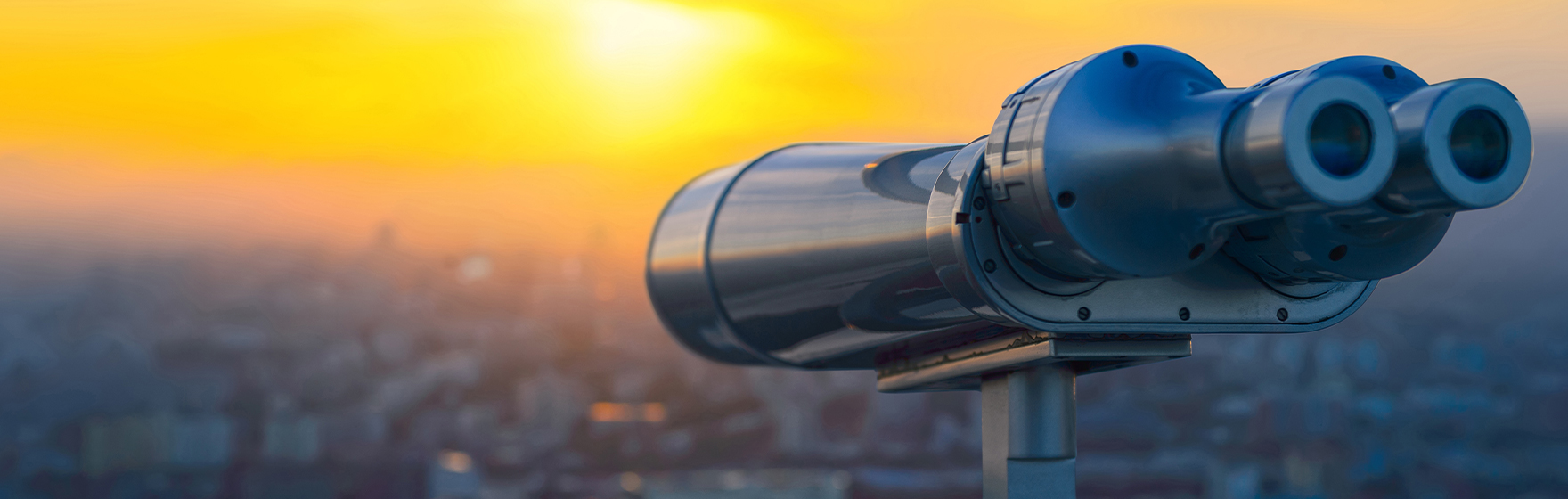Binoculars or telescope on top of skyscraper at observation deck to admire the city skyline at sunset.