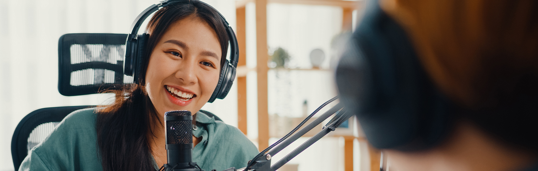 Asia woman records podcast use microphone wear headphones interviewing a guest